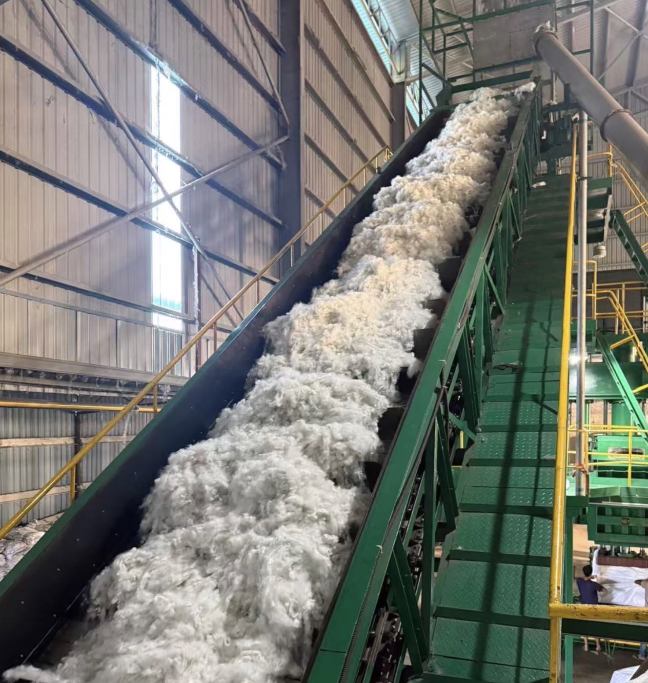 Recycled staple fiber on a conveyor